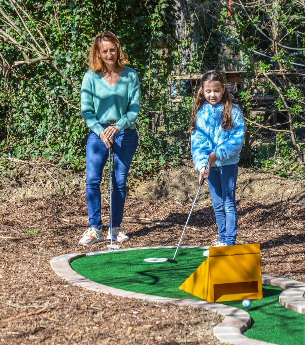 Groupe d'amis riant lors d'une partie de mini-golf